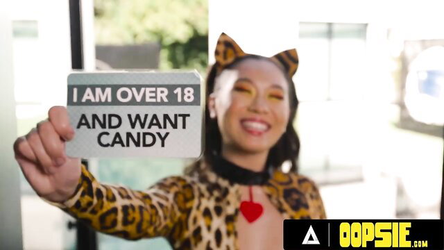 Kimmy Kimm in leopard catsuit holds 'I AM OVER 18 AND WANT CANDY' sign