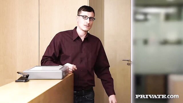 Alexa Tomas in maroon shirt at desk in hot office scene