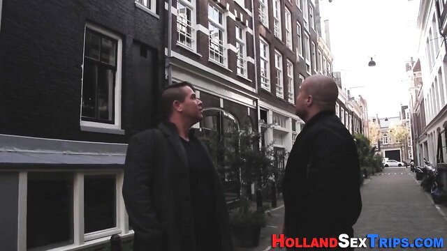 Two inked Dutch guys talking intimately on Amsterdam street