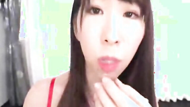 Asian beauty in red lingerie teases with fingers near lips closeup