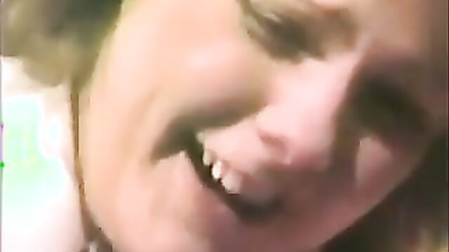 Closeup of mature blonde woman smirking in Spanking Stories adult video