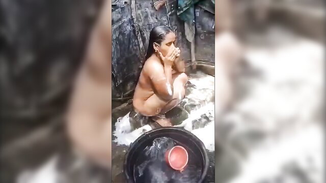 Nude Tamil woman squatting bathing, big wet tits dripping