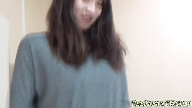 Japanese teen girl smiling in gray sweater, peeing video thumbnail
