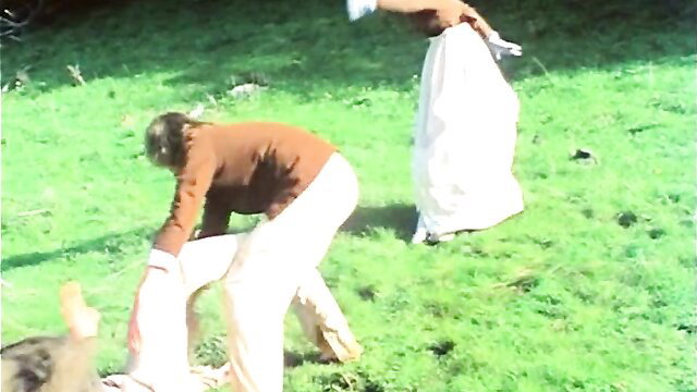 Annette Haven in white dress bending over on grass in 1976 History Lessons