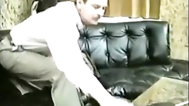 Woman bent over black couch for caning punishment in spanking video