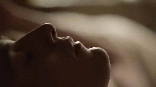 Closeup of seductive woman's face in dim light, sensual lips parted