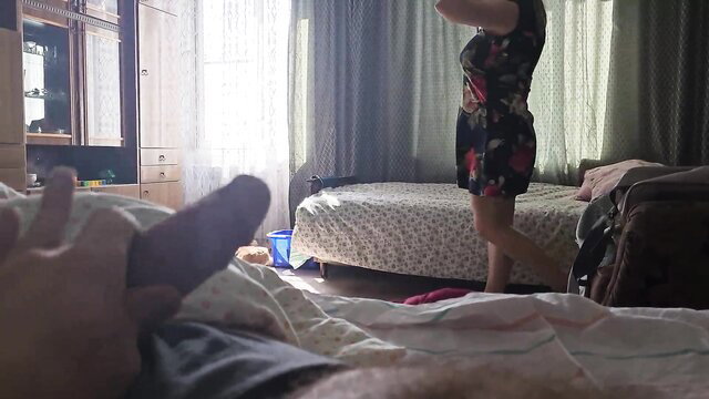 Stepmom in floral dress stands by bed, guy POV handjob with hard cock