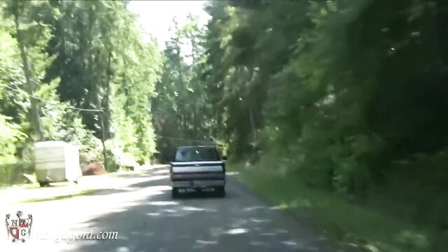 Woman in vacuum bed BDSM scene by van in woods