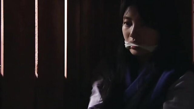 Asian beauty gagged in BDSM bondage, dimly lit JAV scene