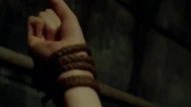 Asian woman's bound wrist in dark BDSM JAV scene