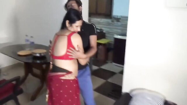 Desi Indian bhabi in red backless blouse and saree hugged by devar in kitchen
