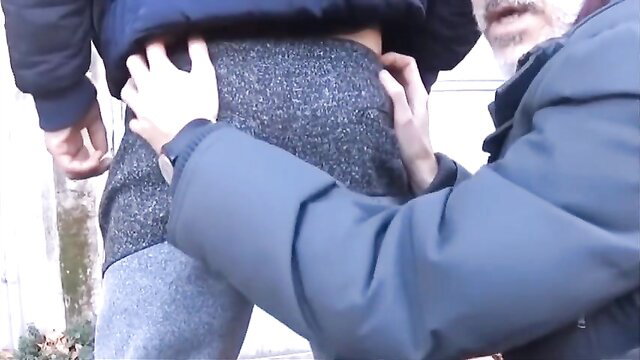 Two men in coats groping gray sweatpants ass outdoors gay tease