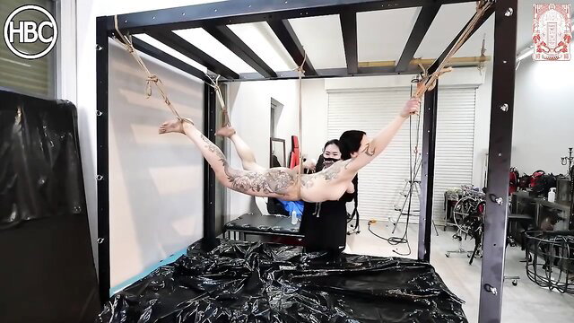 Japanese tattooed woman suspended in BDSM frame for intense tickle torture
