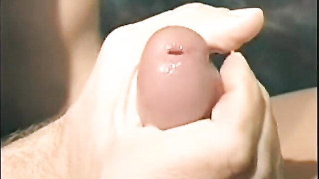 Hand gripping huge erect cock closeup in gay porn thumbnail