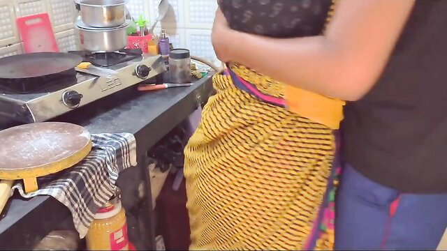 Indian aunty in yellow saree hugs teen boy from behind in kitchen seduction