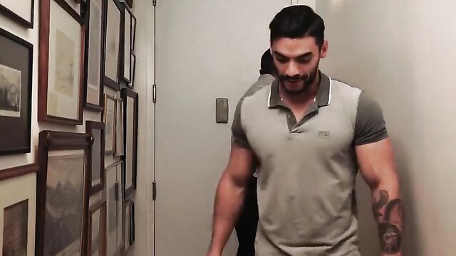 Muscular Latino hunk in tight polo walks hallway, tats flexing