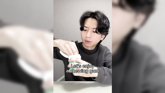 Japanese man chewing gum casually in soft lighting