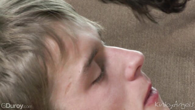 Closeup of nude twink guy with blonde hair lying on couch