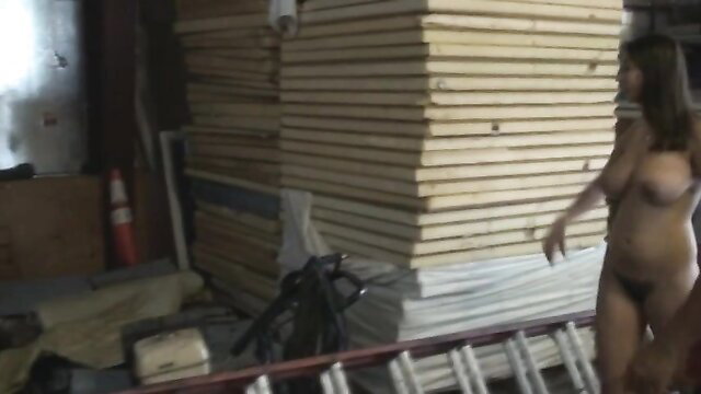 Hairy nude brunette walking topless in public warehouse