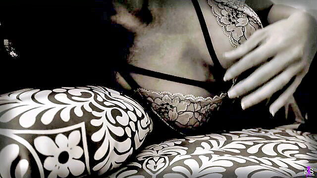 Curvy brunette in sheer lace lingerie teases cleavage on pillows