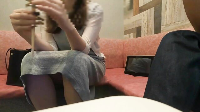 Beautiful Japanese 30yo office worker in skirt holding toy on sofa, voyeur remote work