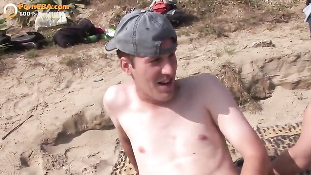 Amateur threesome on beach: nude guy with two others in sand