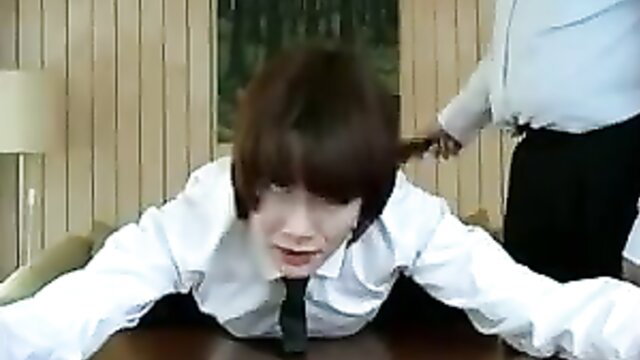 Professor spanks pained male student over desk in office