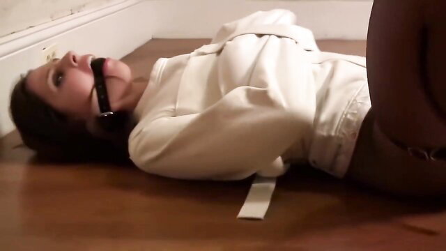 Cali Logan bound and gagged in white sweatsuit BDSM restraint