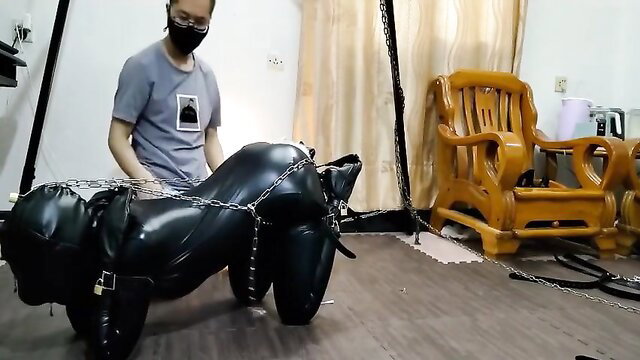 Asian man handles bound leather petgirl in BDSM play