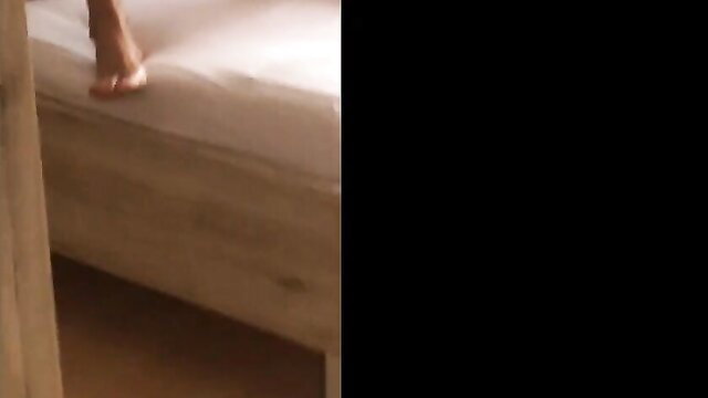 Voyeur home tease: woman's bare foot on bed, sexy legs dangling