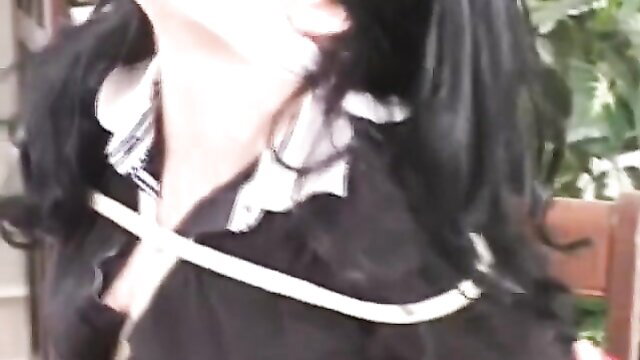 Asian woman in black gothic lolita dress with white rope bondage harness