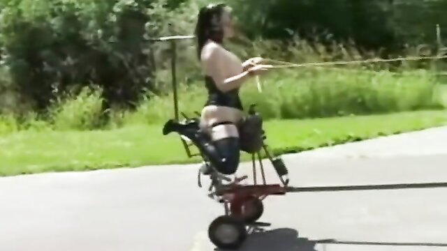 Asian ponygirl in BDSM harness rides outdoor bondage cart in training