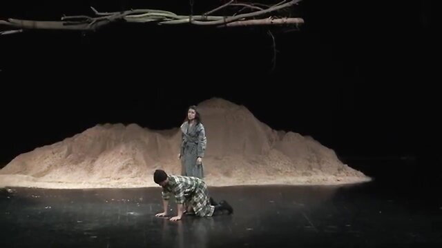 Nude theater performance: man crawls naked on stage before robed woman