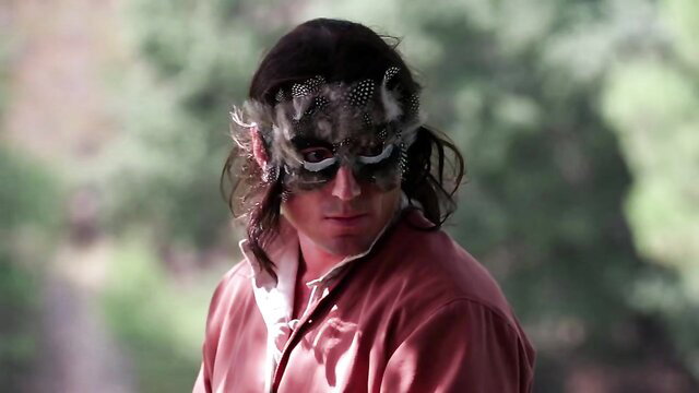 Mysterious masked man in feathered mask and red jacket, BDSM vibe