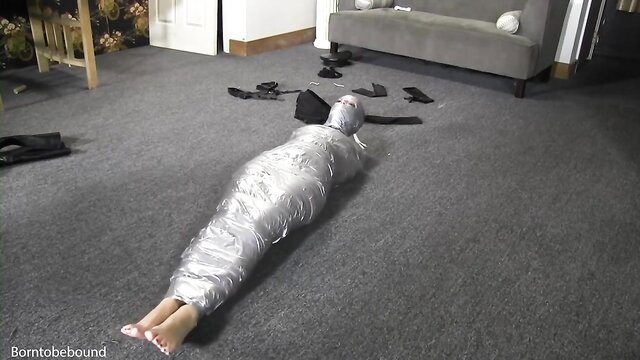 Hot babe mummified in tight duct tape bondage on floor