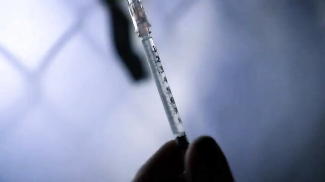 Adriana Chechik holds syringe in intense closeup