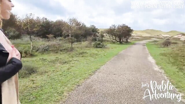 Sarah Calanthe flashes in leather jacket on windy beach path
