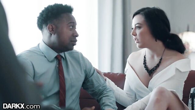 Wife in white dress chats with black sex therapist as husband watches