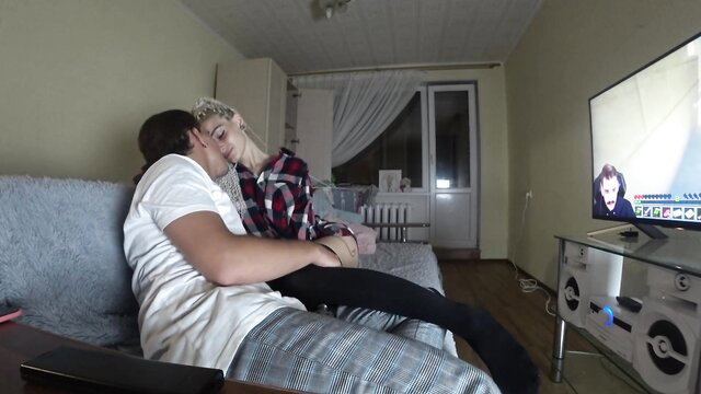 Amateur blonde teen cuddles with boyfriend on couch watching Minecraft letsplay