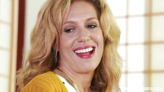 Blonde MILF Rosalyn Sphinx smiling in orange sweater, taboo family watch