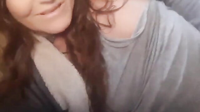 Closeup of smiling brunette woman with cleavage in gray top