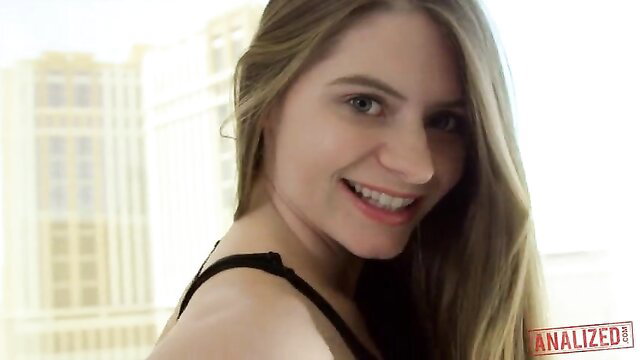 Alice March smiling in black top, long blonde hair, sunny balcony view