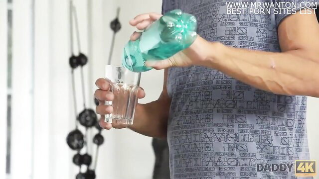 Daddy4K muscular man pouring drink into glass in gym