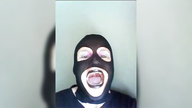 Masked woman screaming in black balaclava, explicit mouth open closeup