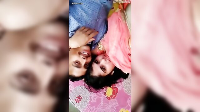 Indian couple in pink saree lying on bed, smiling close-up