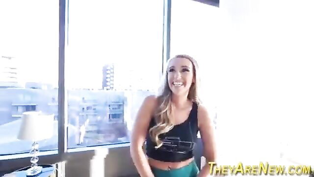 Harley Jade smiling in tank top and shorts in sunny hotel room