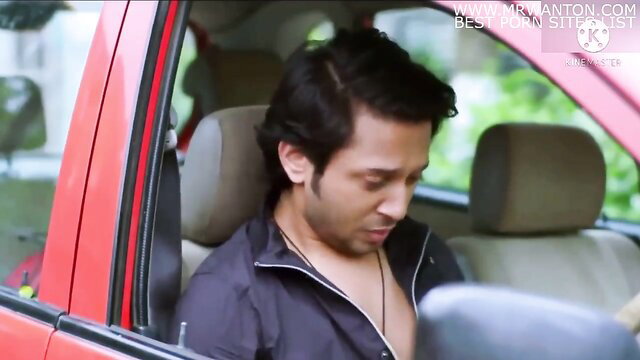 Handsome Indian man in car, intense gaze, shirt open, necklace visible