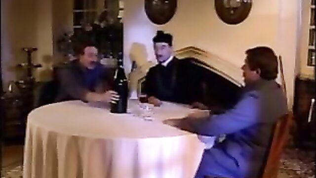 Three men in suits at table with wine in Maximum Perversum