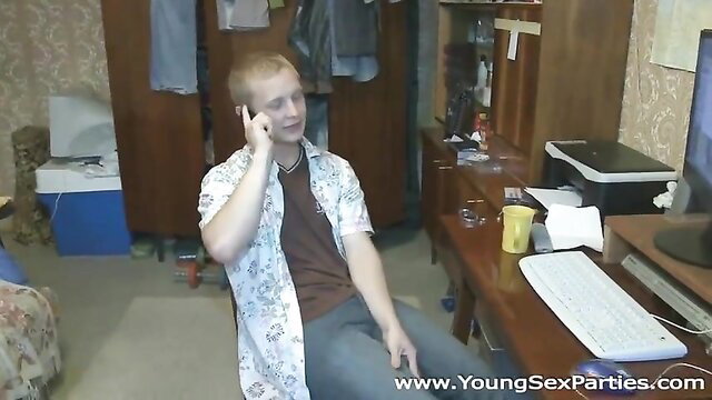 Young man on phone in a room with a computer and desk