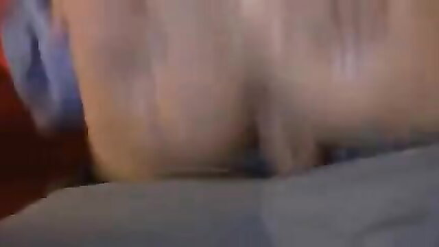 Blurry closeup of pale woman's big ass in blue thong bending over bed